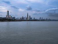 an industrial area in the city with water and sky in background at dusk on a cloudy day