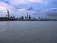 an industrial area in the city with water and sky in background at dusk on a cloudy day