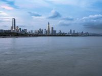 an industrial area in the city with water and sky in background at dusk on a cloudy day