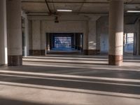 the sunlight shines through the window of an empty building filled with columns and pillars