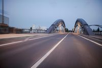 a long road next to a bridge with lights on it's sides and a street under them