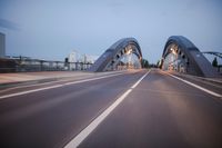 a long road next to a bridge with lights on it's sides and a street under them