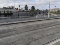 the side of the freeway has empty spaces with several lanes and railings, along with an overpass