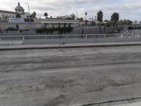 the side of the freeway has empty spaces with several lanes and railings, along with an overpass