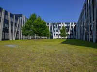 a building surrounded by grass and other greenery areas is set aside by a few trees