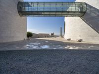 a woman stands in an archway near a statue and museum like building on the other side