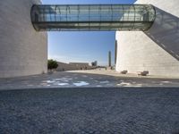 a woman stands in an archway near a statue and museum like building on the other side