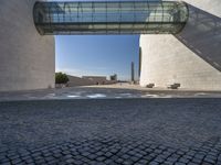 a woman stands in an archway near a statue and museum like building on the other side