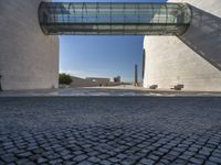 a woman stands in an archway near a statue and museum like building on the other side