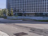 a person walking down a deserted city street with skyscrapers in the background in the daytime