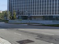 a person walking down a deserted city street with skyscrapers in the background in the daytime