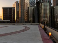 two orange candle lamps sit on a building platform with some tall buildings in the background