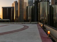 two orange candle lamps sit on a building platform with some tall buildings in the background