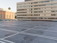 a parking lot with two building in the background and buildings all along side each other