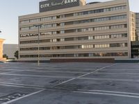 a parking lot with two building in the background and buildings all along side each other