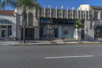 the store front of zara by a street with palm trees and building in the background