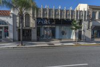 the store front of zara by a street with palm trees and building in the background