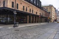 a brick sidewalk and street with buildings in the background of it and people walking around