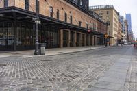 a brick sidewalk and street with buildings in the background of it and people walking around