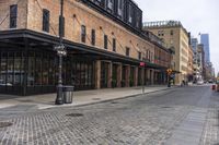 a brick sidewalk and street with buildings in the background of it and people walking around