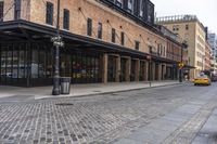 a brick sidewalk and street with buildings in the background of it and people walking around