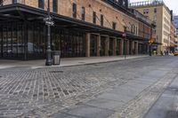 a brick sidewalk and street with buildings in the background of it and people walking around