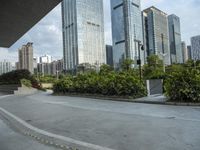 a couple of people riding skate boards near tall buildings on the street, in front of them is a walkway