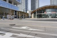 an empty street with buildings and an urban street scene in the background the road has many white lines in it