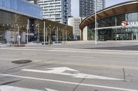 an empty street with buildings and an urban street scene in the background the road has many white lines in it