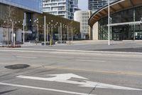 an empty street with buildings and an urban street scene in the background the road has many white lines in it