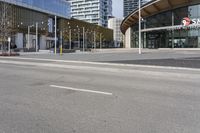 an empty street with buildings and an urban street scene in the background the road has many white lines in it