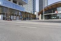 an empty street with buildings and an urban street scene in the background the road has many white lines in it