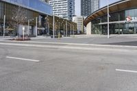 an empty street with buildings and an urban street scene in the background the road has many white lines in it