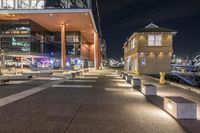 there is a paved walkway along the building's exterior with buildings in the background