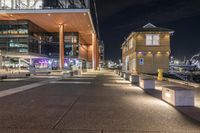 there is a paved walkway along the building's exterior with buildings in the background