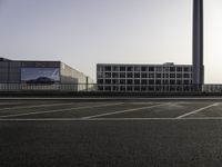 a parking lot with cars parked on it and buildings behind it with sky scrapers