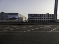 a parking lot with cars parked on it and buildings behind it with sky scrapers