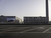 a parking lot with cars parked on it and buildings behind it with sky scrapers