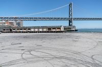 an empty parking lot with car tires painted on it and a boat dock in the back ground