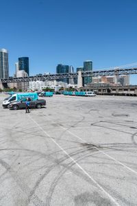 an empty parking lot with car tires painted on it and a boat dock in the back ground