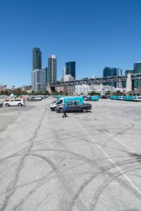 an empty parking lot with car tires painted on it and a boat dock in the back ground