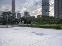 large empty public square in urban city area with skyscrapers and lawn in foreground