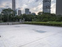 large empty public square in urban city area with skyscrapers and lawn in foreground