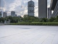 large empty public square in urban city area with skyscrapers and lawn in foreground