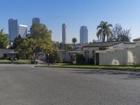 the view of a neighborhood with trees and buildings behind it is clear blue skies and a sun shines above