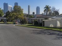 the view of a neighborhood with trees and buildings behind it is clear blue skies and a sun shines above