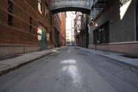 an alley way with people walking along and two cars in the street and buildings behind