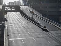 a street with two lanes, the road is empty and the truck on the side of it is driving through traffic