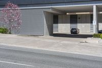 a black car sitting in a parking garage in front of a building next to the road