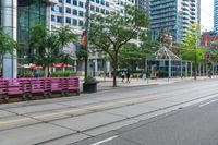 empty city street with lots of crates and people in the background, including some with umbrellas